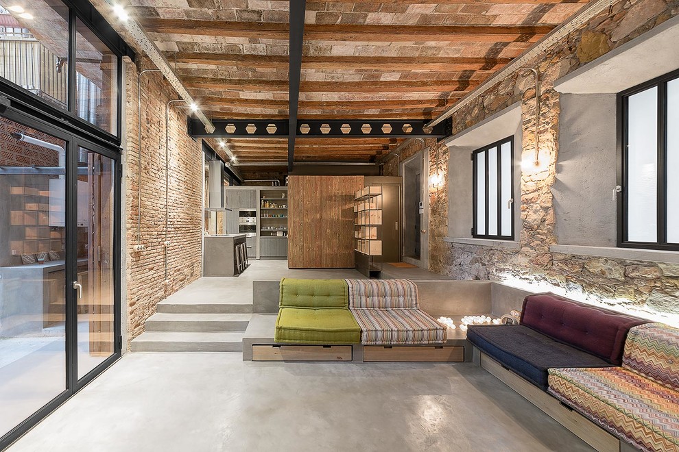 Photo of a large industrial formal open concept living room in Barcelona with concrete floors and no tv.