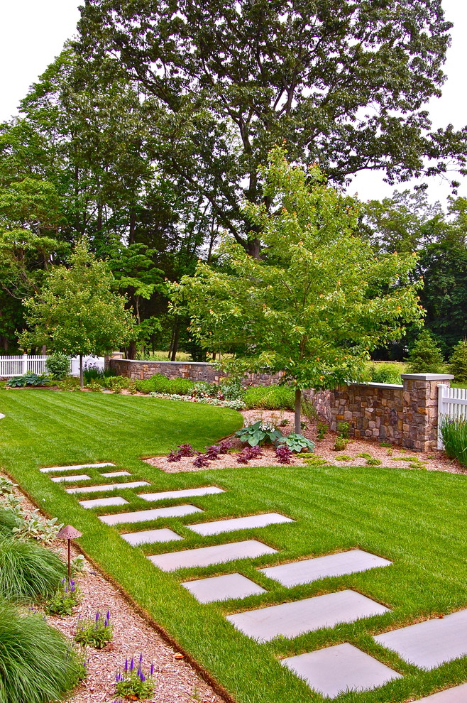This is an example of an expansive traditional backyard garden in New York.