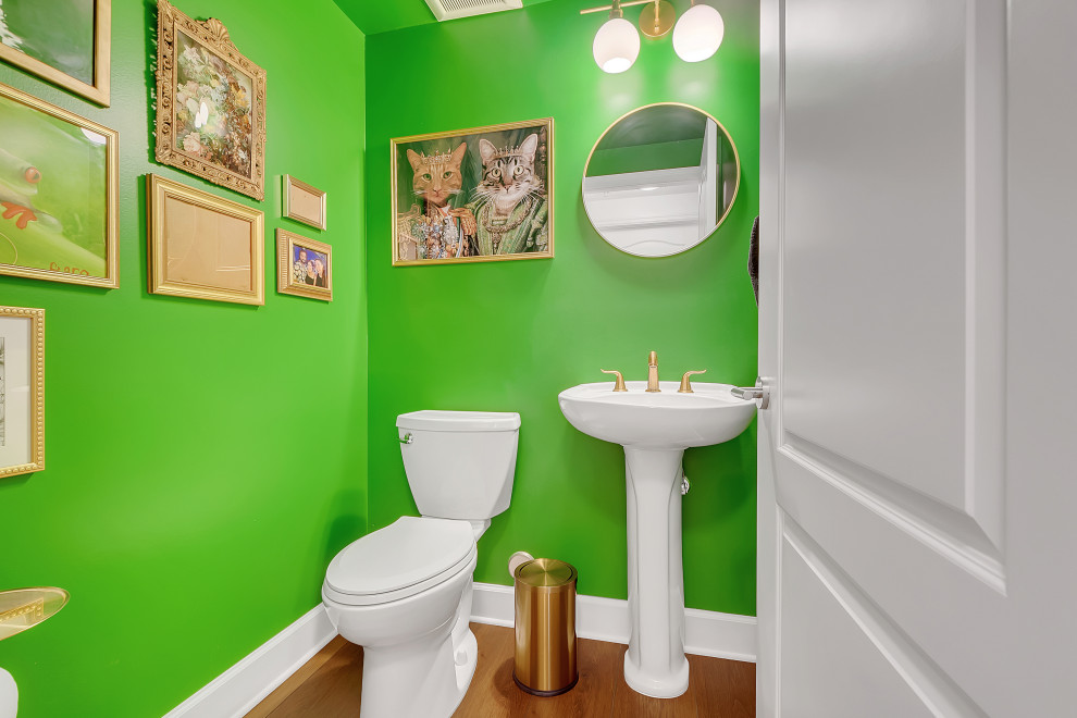 Exemple d'un WC et toilettes moderne de taille moyenne avec un placard à porte affleurante, des portes de placard blanches, WC à poser, un mur vert, un sol en vinyl, un lavabo posé, un plan de toilette en calcaire, un sol marron, un plan de toilette blanc, meuble-lavabo suspendu et un plafond voûté.