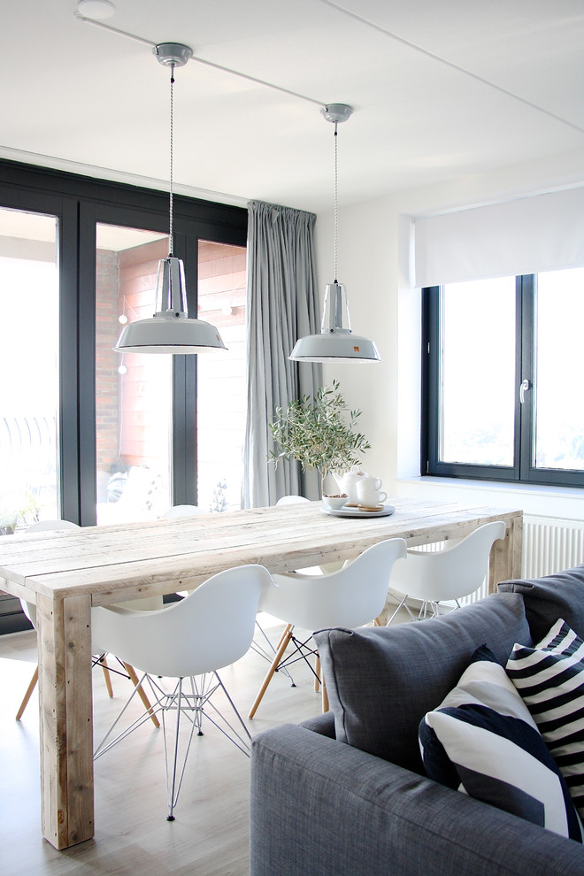 Inspiration for a scandinavian dining room in Amsterdam with white walls and light hardwood floors.
