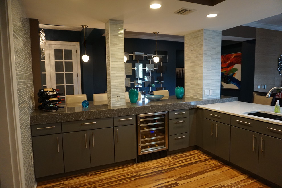 Photo of a mid-sized modern home bar in Tampa with an undermount sink, glass-front cabinets, grey cabinets, recycled glass benchtops, grey splashback, matchstick tile splashback, vinyl floors and brown floor.