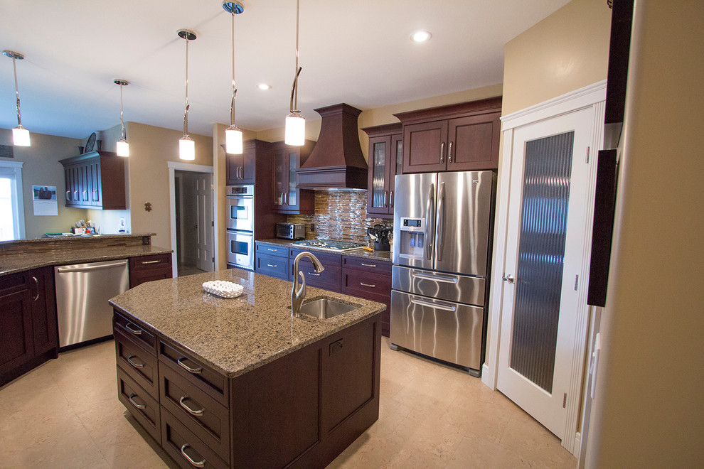 Mid-sized transitional l-shaped enclosed kitchen photo with an undermount sink, recessed-panel cabinets, medium tone wood cabinets, granite countertops, stainless steel appliances and an island