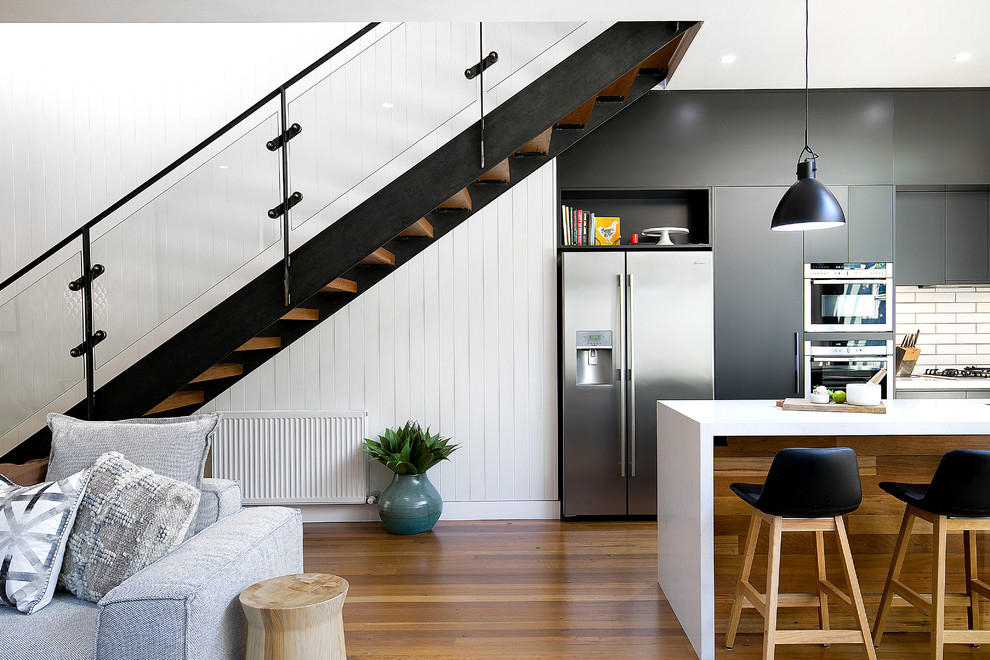 This is an example of a contemporary wood straight staircase in Sydney with open risers and metal railing.