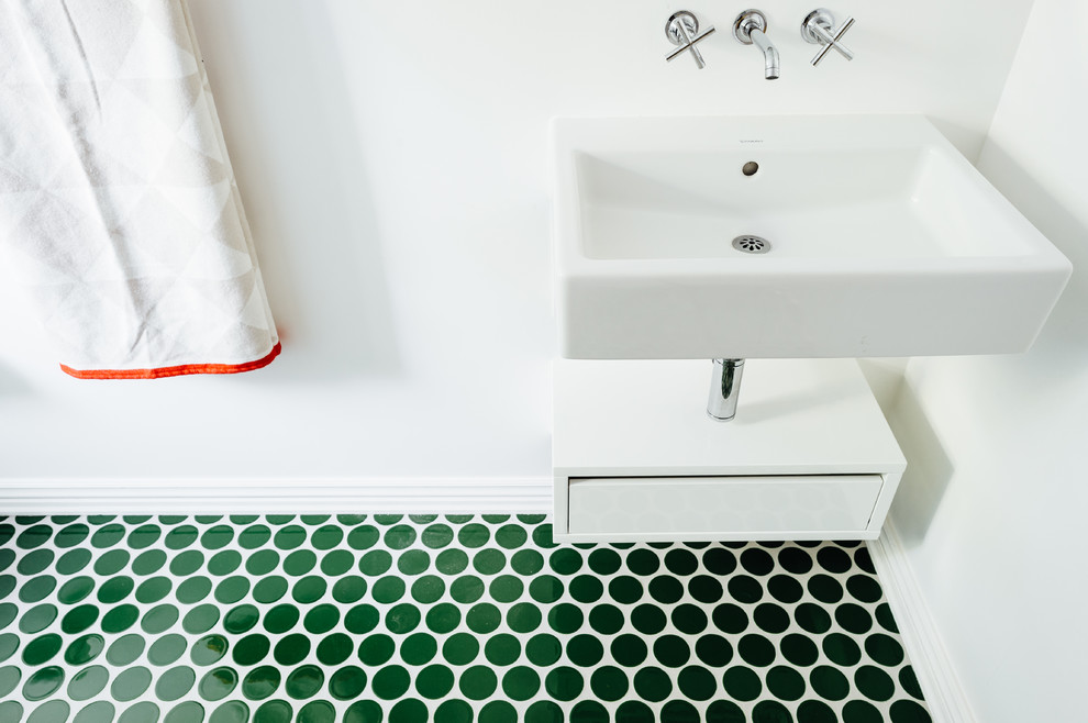 Photo of a small scandinavian powder room in Salt Lake City with white walls, porcelain floors, a wall-mount sink and green floor.