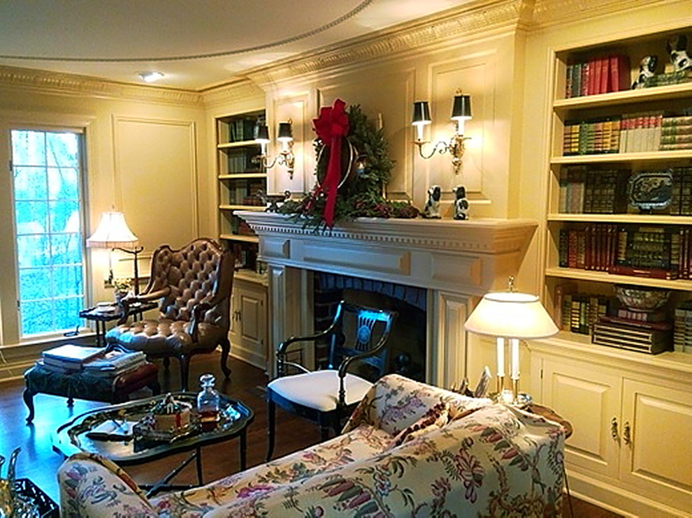 Inspiration for a mid-sized eclectic enclosed living room in Chicago with a library, yellow walls, dark hardwood floors, a standard fireplace, a wood fireplace surround and no tv.