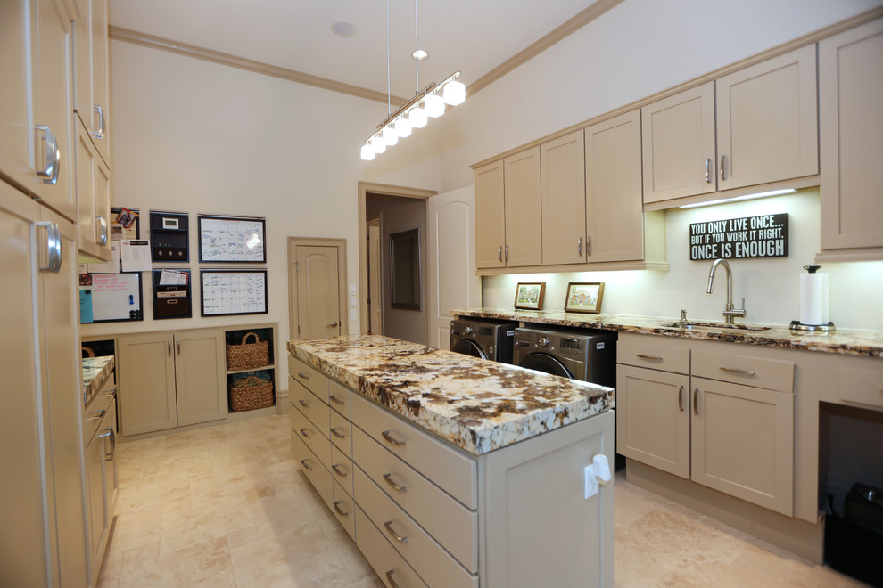 Photo of an expansive contemporary utility room in Houston with an undermount sink, recessed-panel cabinets, marble benchtops, travertine floors and a side-by-side washer and dryer.