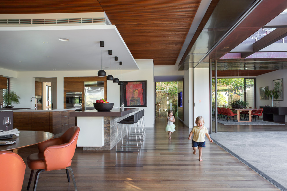 Photo of a large contemporary kitchen in Perth with an undermount sink, flat-panel cabinets, dark wood cabinets, granite benchtops, stone slab splashback, stainless steel appliances, medium hardwood floors and multiple islands.