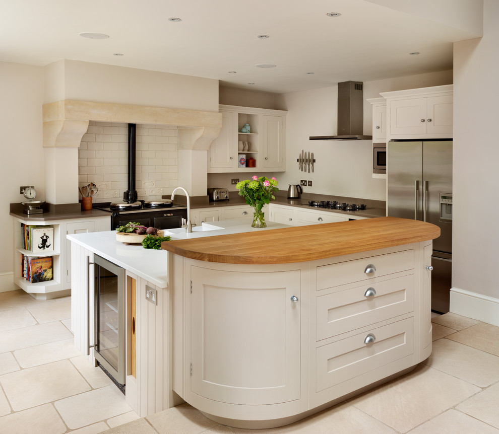 Design ideas for a country l-shaped kitchen in London with shaker cabinets, white cabinets, white splashback, subway tile splashback, stainless steel appliances and with island.