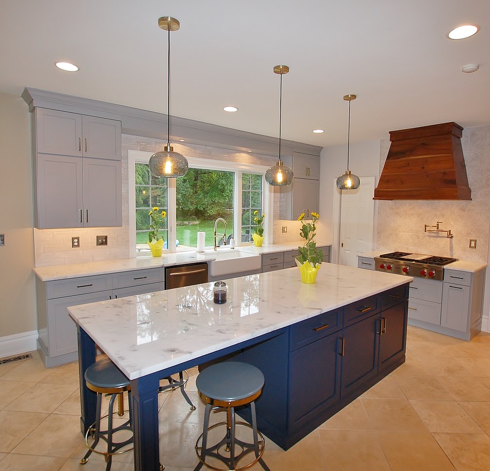 Photo of a large l-shaped eat-in kitchen in Philadelphia with a farmhouse sink, flat-panel cabinets, blue cabinets, marble benchtops, white splashback, subway tile splashback, stainless steel appliances, dark hardwood floors, with island, brown floor and white benchtop.