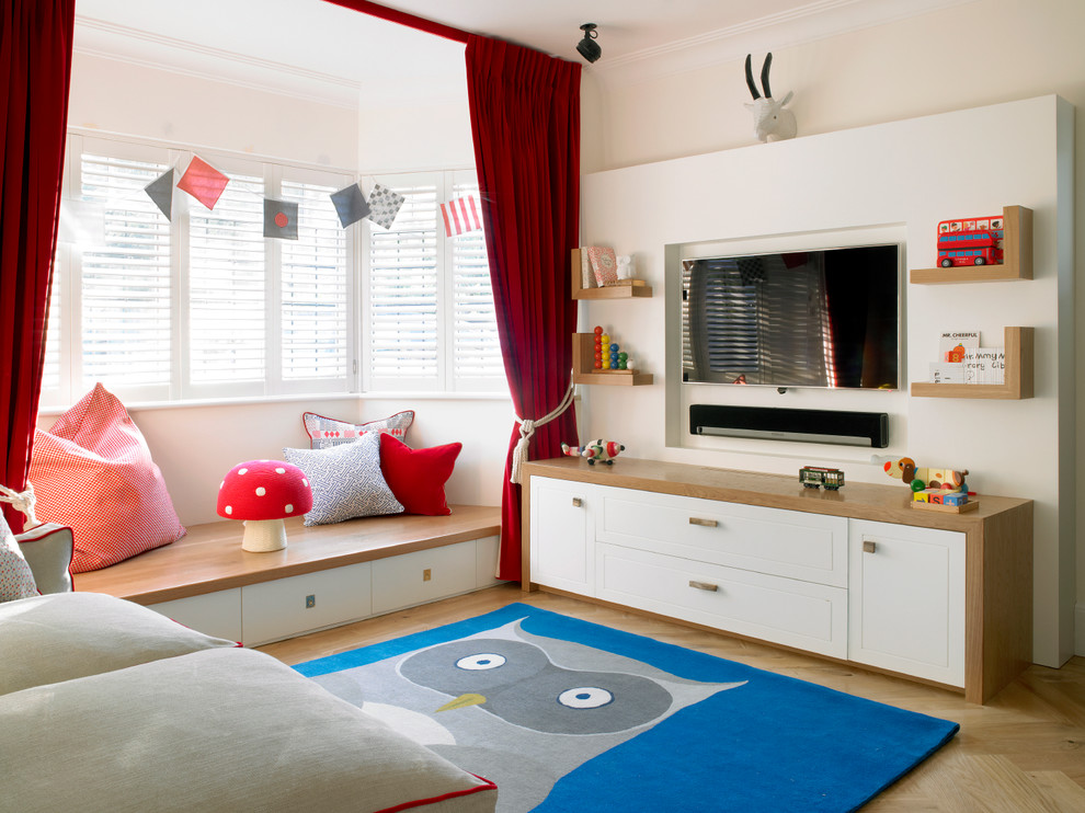 Inspiration for a mid-sized transitional kids' playroom in London with white walls and light hardwood floors.