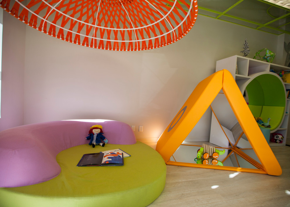 Inspiration for a large modern gender-neutral kids' playroom for kids 4-10 years old in Omaha with white walls and light hardwood floors.