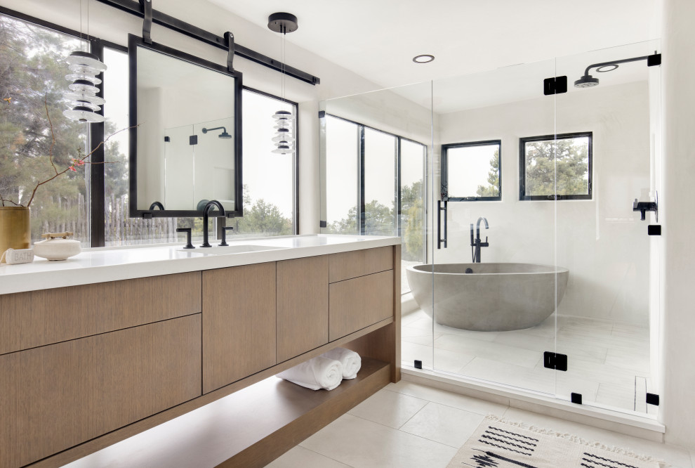 Photo of a large master wet room bathroom in Albuquerque with flat-panel cabinets, a freestanding tub, porcelain floors, beige floor, a hinged shower door, a double vanity, a built-in vanity and wood.
