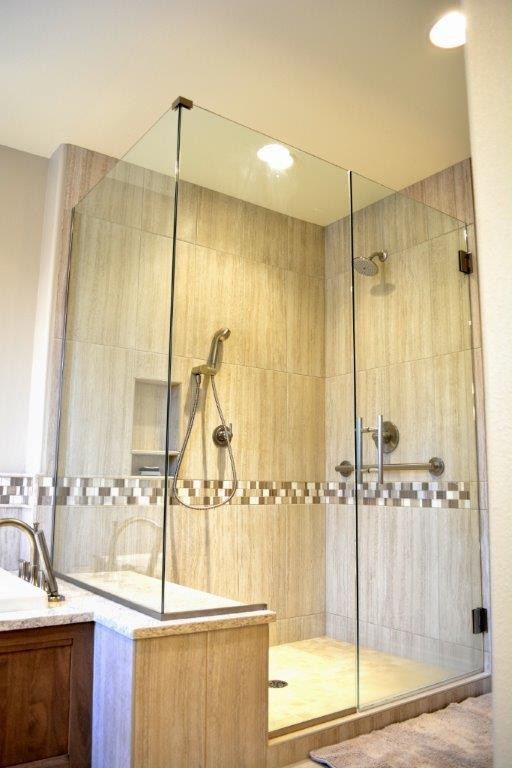 This is an example of a mid-sized transitional master bathroom in Denver with shaker cabinets, light wood cabinets, a drop-in tub, a corner shower, a two-piece toilet, beige tile, porcelain tile, beige walls, ceramic floors, an undermount sink, beige floor and a hinged shower door.
