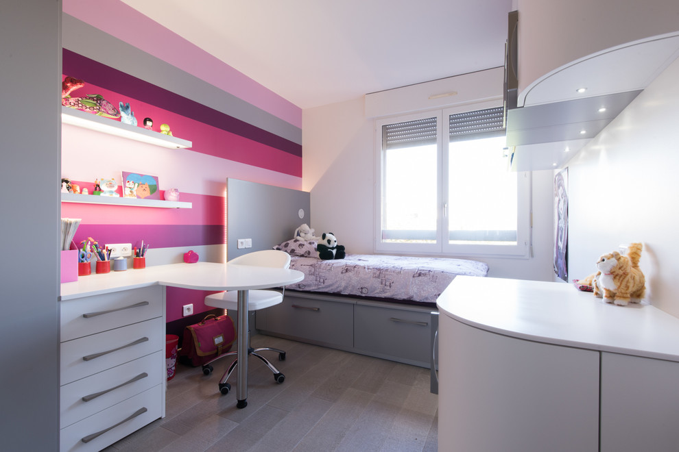 Mid-sized contemporary kids' bedroom in Paris with light hardwood floors and multi-coloured walls for kids 4-10 years old and girls.