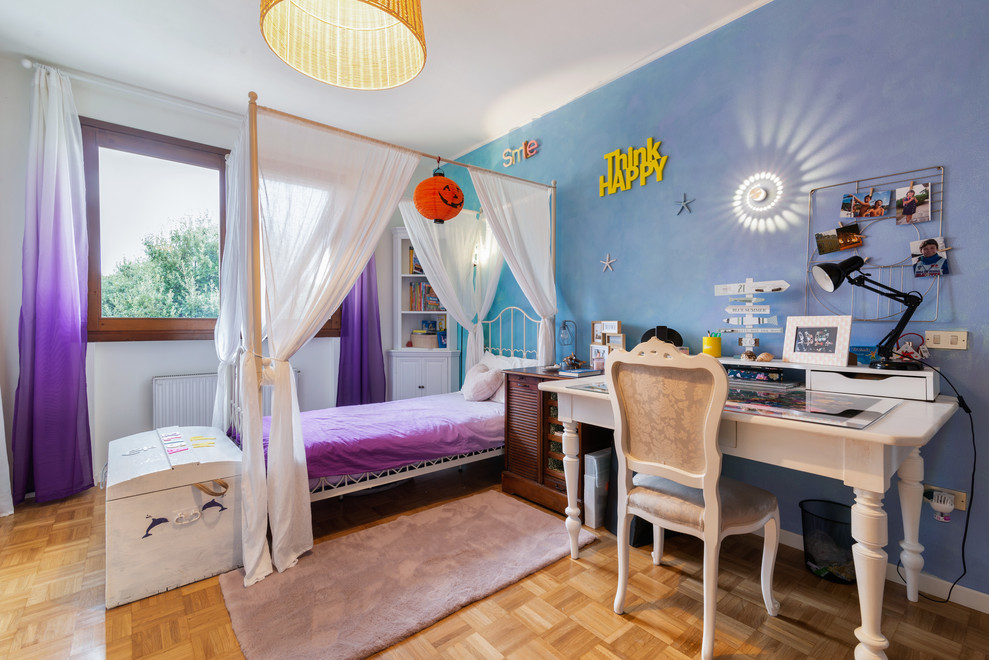 Photo of a mid-sized modern gender-neutral kids' room in Other with multi-coloured walls.