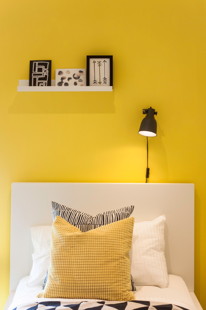 Photo of a small contemporary master bedroom in London with yellow walls, carpet and beige floor.