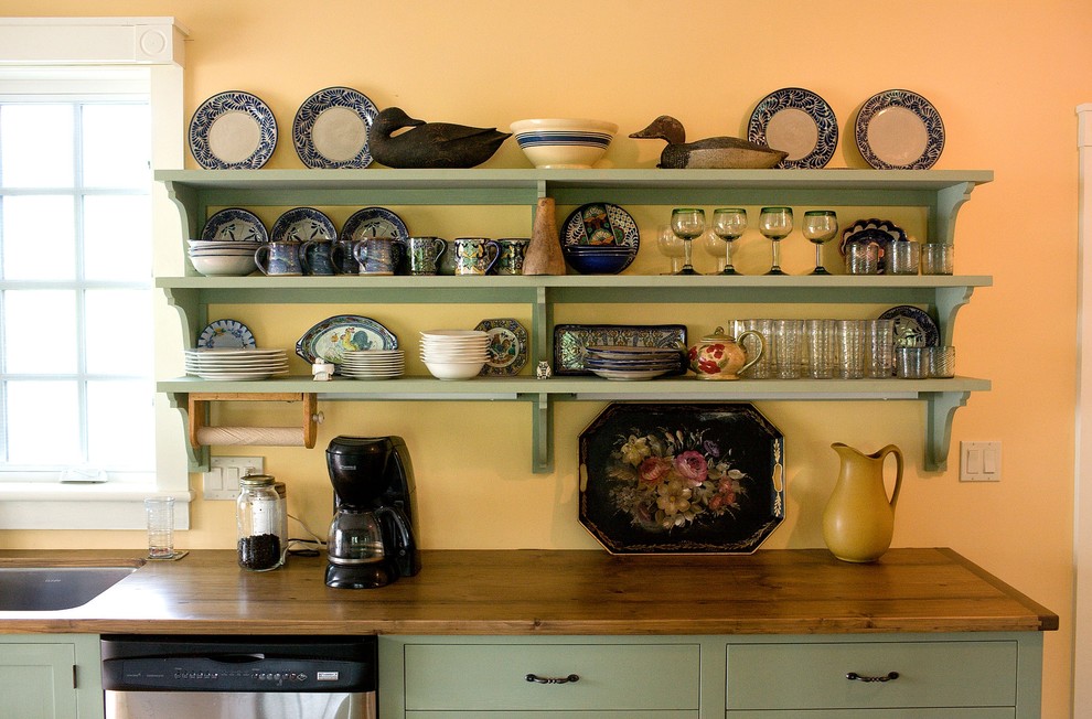 Country kitchen in Boston with wood benchtops, open cabinets and green cabinets.