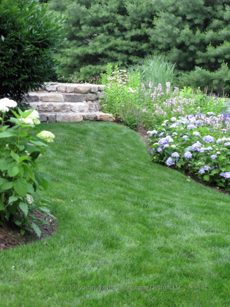 Traditional side yard partial sun garden in Bridgeport with natural stone pavers for summer.