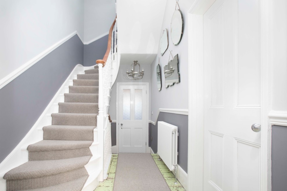 This is an example of an expansive beach style hallway in Kent with grey walls, dark hardwood floors and green floor.