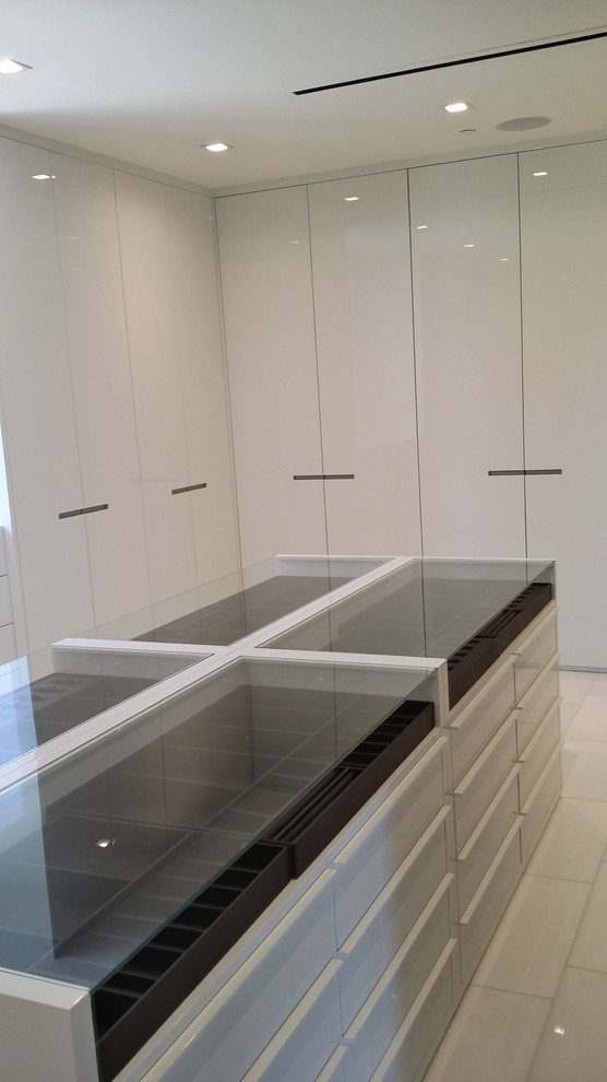 Inspiration for a large modern gender-neutral walk-in wardrobe in Los Angeles with flat-panel cabinets, white cabinets, marble floors and white floor.