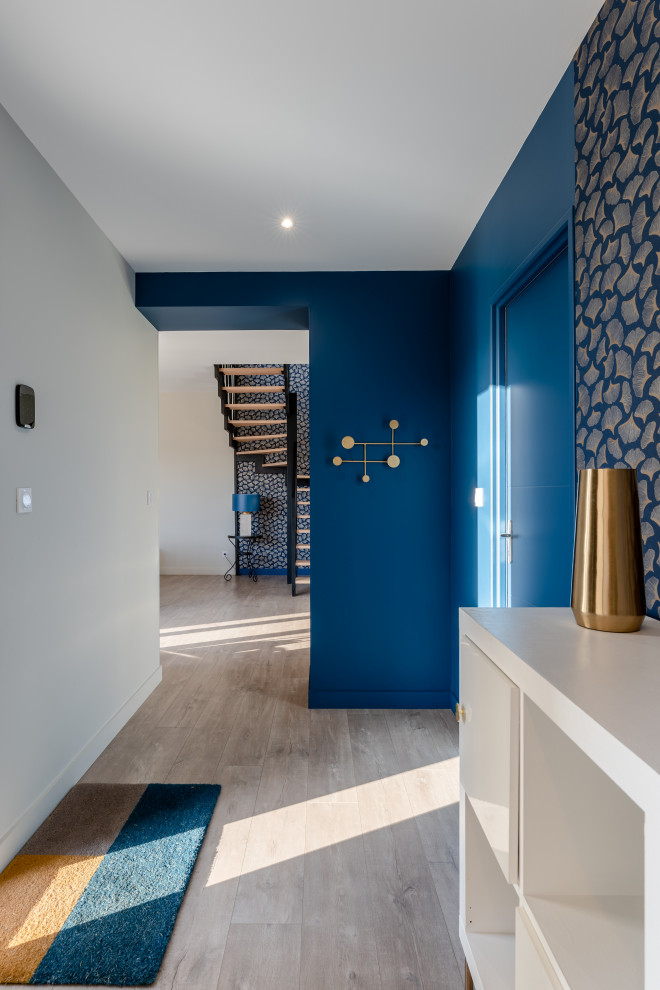 Стильный дизайн: большое фойе в стиле фьюжн с синими стенами, полом из ламината, двустворчатой входной дверью, черной входной дверью и обоями на стенах - последний тренд