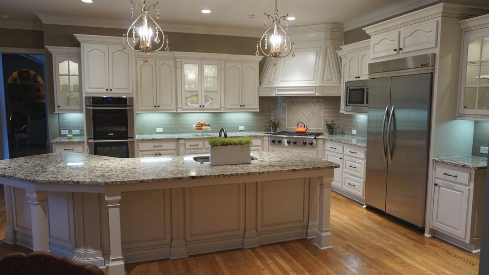 This is an example of a large traditional u-shaped eat-in kitchen in Atlanta with an undermount sink, raised-panel cabinets, white cabinets, granite benchtops, grey splashback, ceramic splashback, stainless steel appliances, medium hardwood floors and with island.