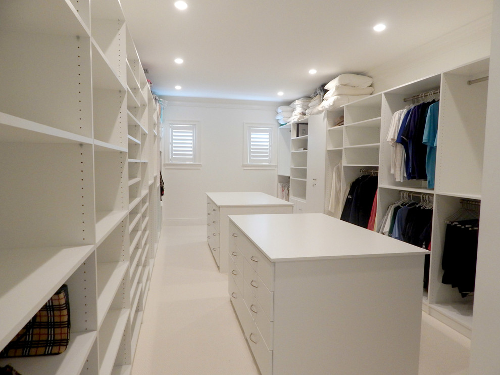 Photo of an expansive contemporary gender-neutral walk-in wardrobe in Other with open cabinets and white cabinets.