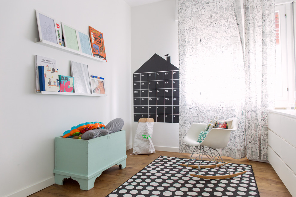 Photo of a scandinavian gender-neutral kids' playroom for kids 4-10 years old in Venice with white walls and dark hardwood floors.