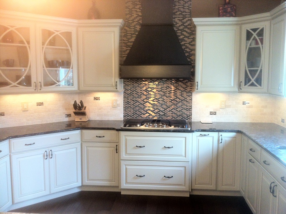 Inspiration for a mid-sized modern u-shaped enclosed kitchen remodel in Chicago with raised-panel cabinets, white cabinets, granite countertops, beige backsplash, cement tile backsplash, stainless steel appliances and an island