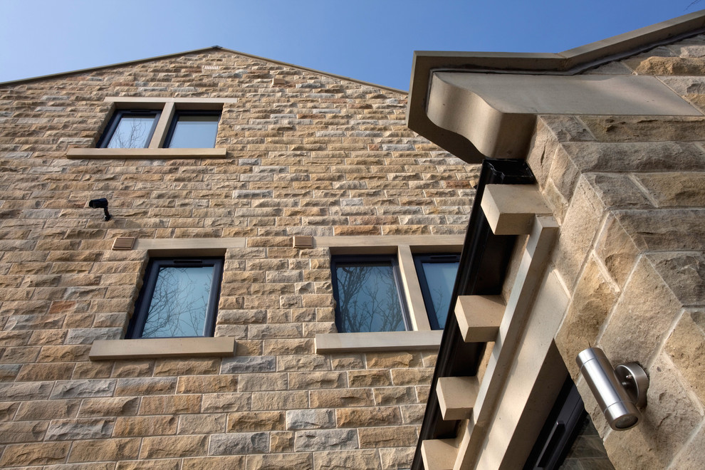 Inspiration for a large contemporary two-storey beige exterior in Other with stone veneer.