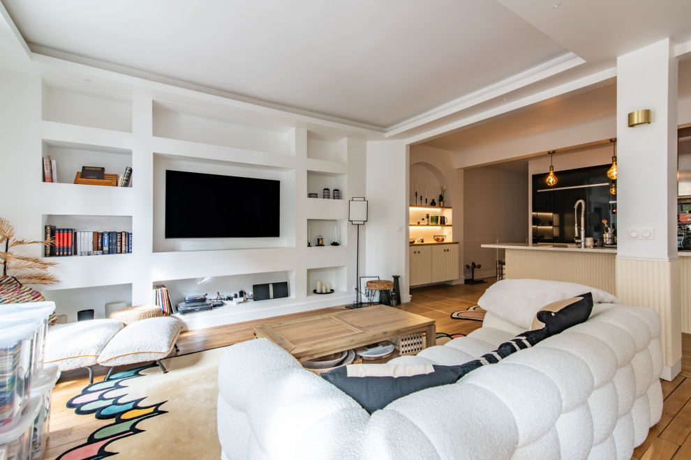 This is an example of a contemporary family room in Other with white walls, medium hardwood floors, a wall-mounted tv, brown floor and recessed.