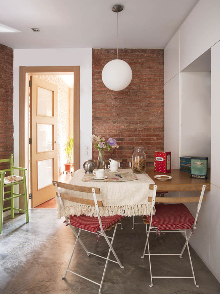 Transitional dining room in Barcelona with concrete floors, grey floor and red walls.
