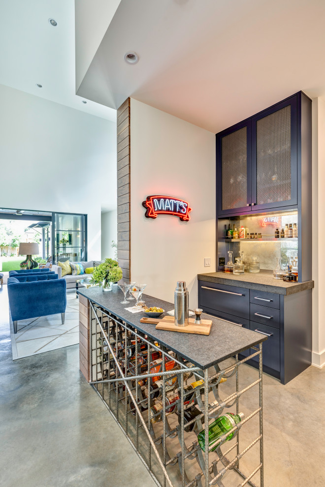 Inspiration for a modern galley home bar in Houston with flat-panel cabinets, blue cabinets, concrete benchtops, mirror splashback, concrete floors, grey floor and grey benchtop.