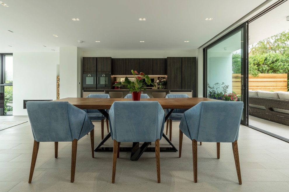 This is an example of a beach style open plan dining in Cheshire with white walls and grey floor.