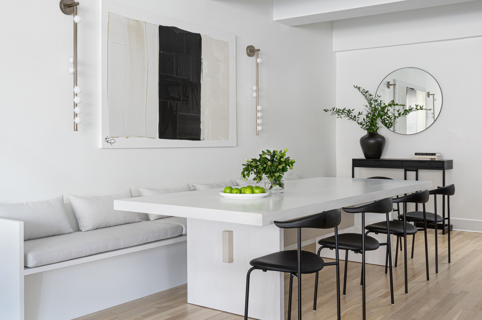 Idée de décoration pour une grande salle à manger ouverte sur la cuisine design avec un mur blanc et parquet clair.
