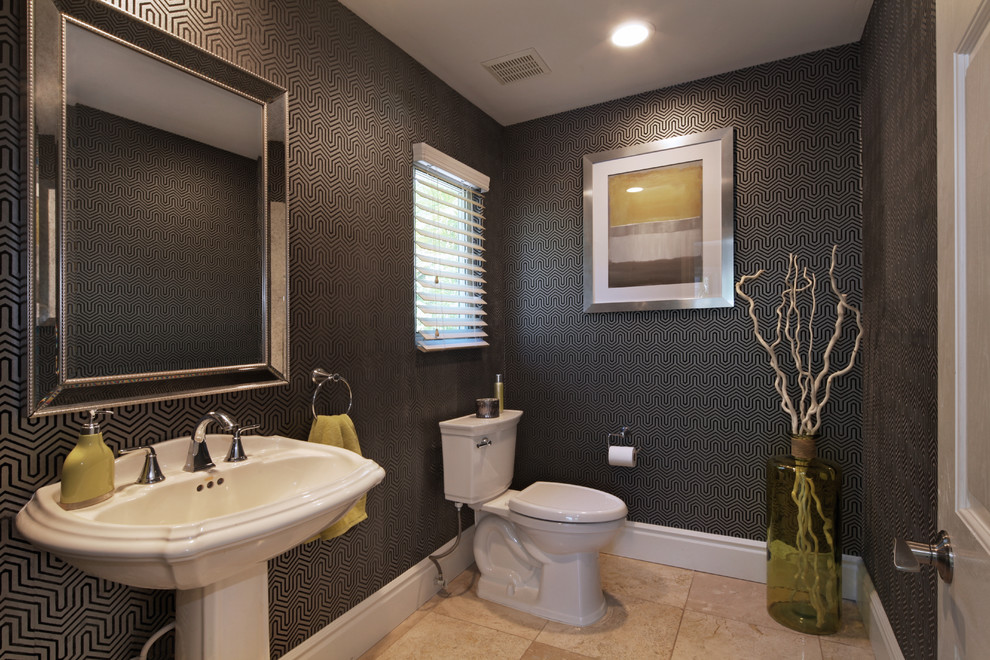 This is an example of a small contemporary powder room in Orange County with a two-piece toilet, black walls, a pedestal sink and beige floor.