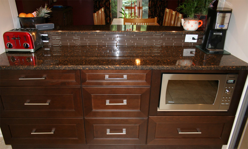 Example of a mid-sized transitional u-shaped porcelain tile eat-in kitchen design in Toronto with a farmhouse sink, shaker cabinets, dark wood cabinets, quartz countertops, brown backsplash, ceramic backsplash, stainless steel appliances and a peninsula
