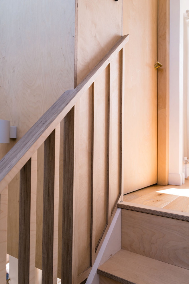 Design ideas for a medium sized contemporary wood straight wood railing staircase spindle in London with wood risers.