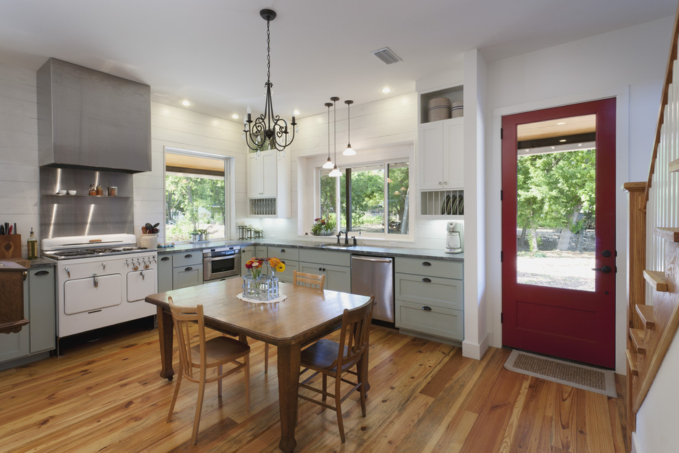 This is an example of a country eat-in kitchen in Austin with white appliances, green cabinets and shaker cabinets.