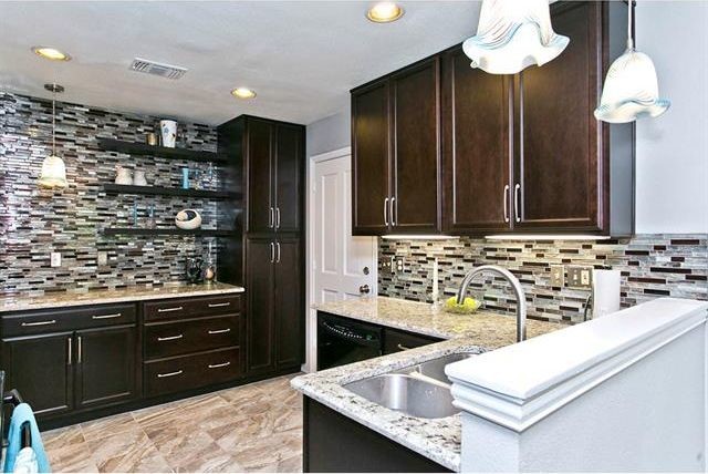 Small transitional u-shaped ceramic tile eat-in kitchen photo in Dallas with an undermount sink, shaker cabinets, dark wood cabinets, granite countertops, brown backsplash, glass tile backsplash, black appliances and no island
