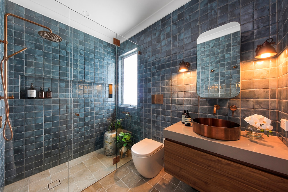 Inspiration for a small contemporary bathroom in Sydney with flat-panel cabinets, brown cabinets, a wall-mount toilet, blue tile, ceramic tile, blue walls, ceramic floors, a vessel sink, engineered quartz benchtops, grey floor, grey benchtops, a single vanity and a floating vanity.