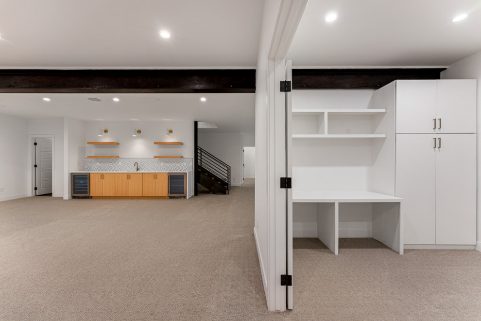 This is an example of a modern gender-neutral kids' playroom in Denver with white walls, carpet, grey floor and exposed beam.
