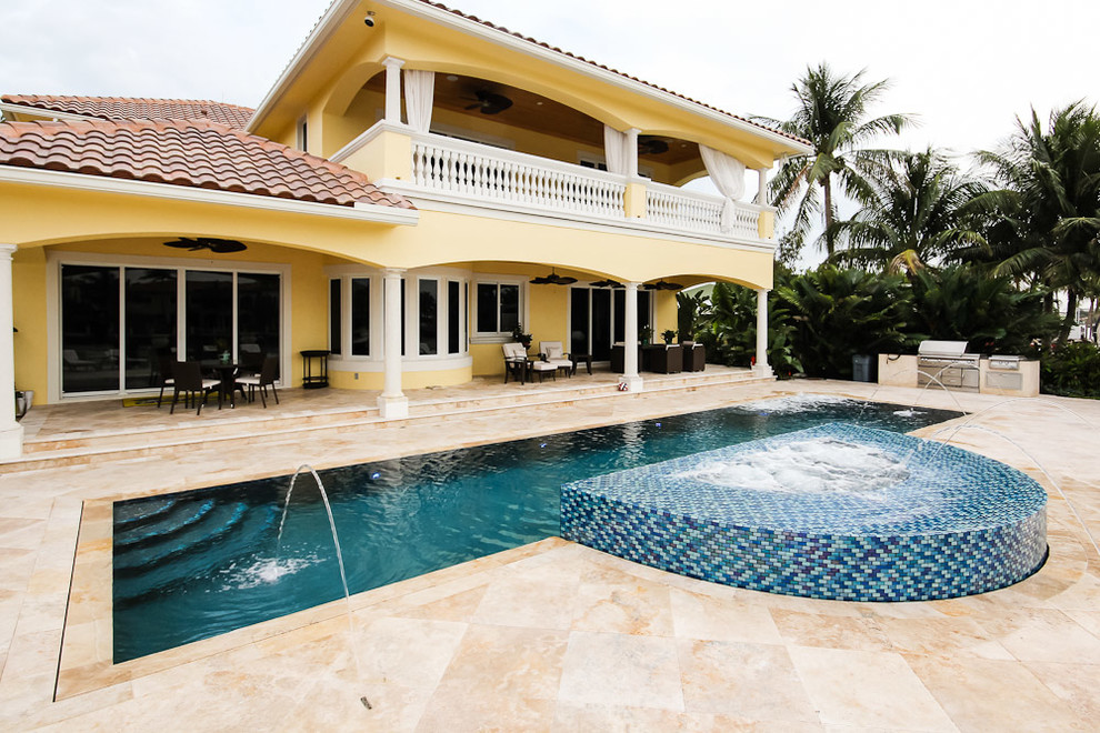 Design ideas for a large backyard rectangular lap pool in Miami with a hot tub and natural stone pavers.