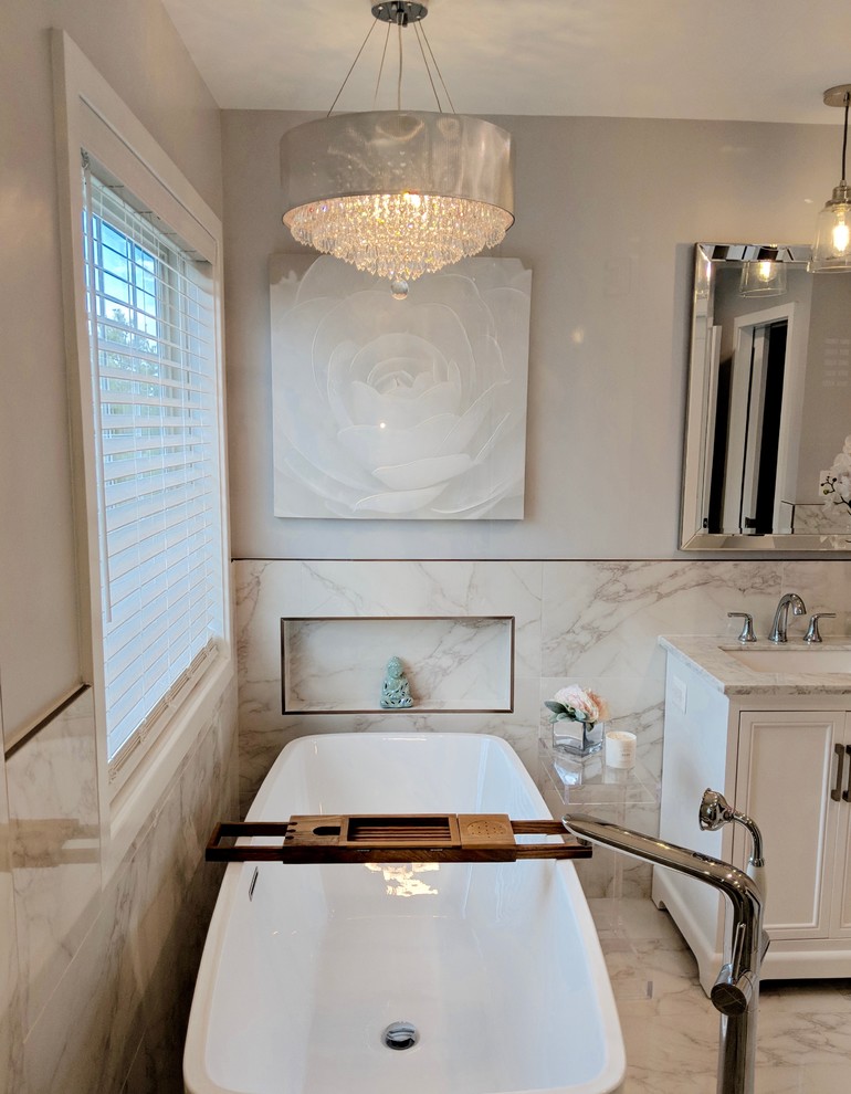 Example of a mid-sized transitional master gray tile and ceramic tile ceramic tile and gray floor freestanding bathtub design in DC Metro with shaker cabinets, white cabinets, a one-piece toilet, gray walls, an undermount sink, marble countertops, a hinged shower door and gray countertops
