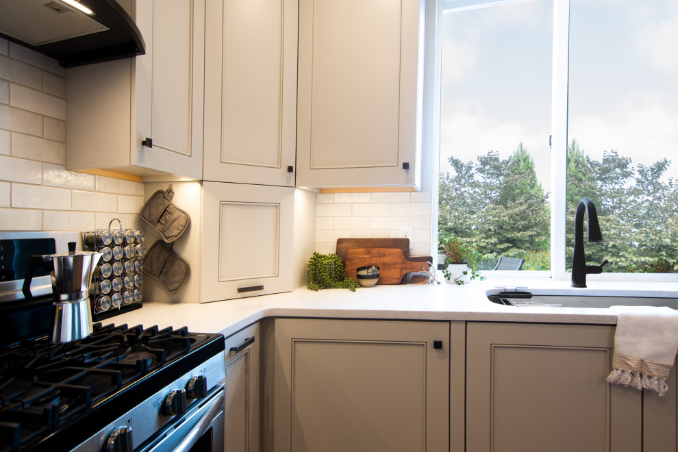 Kitchen - mid-sized transitional l-shaped medium tone wood floor and brown floor kitchen idea with an undermount sink, recessed-panel cabinets, gray cabinets, quartz countertops, white backsplash, ceramic backsplash, stainless steel appliances, a peninsula and white countertops
