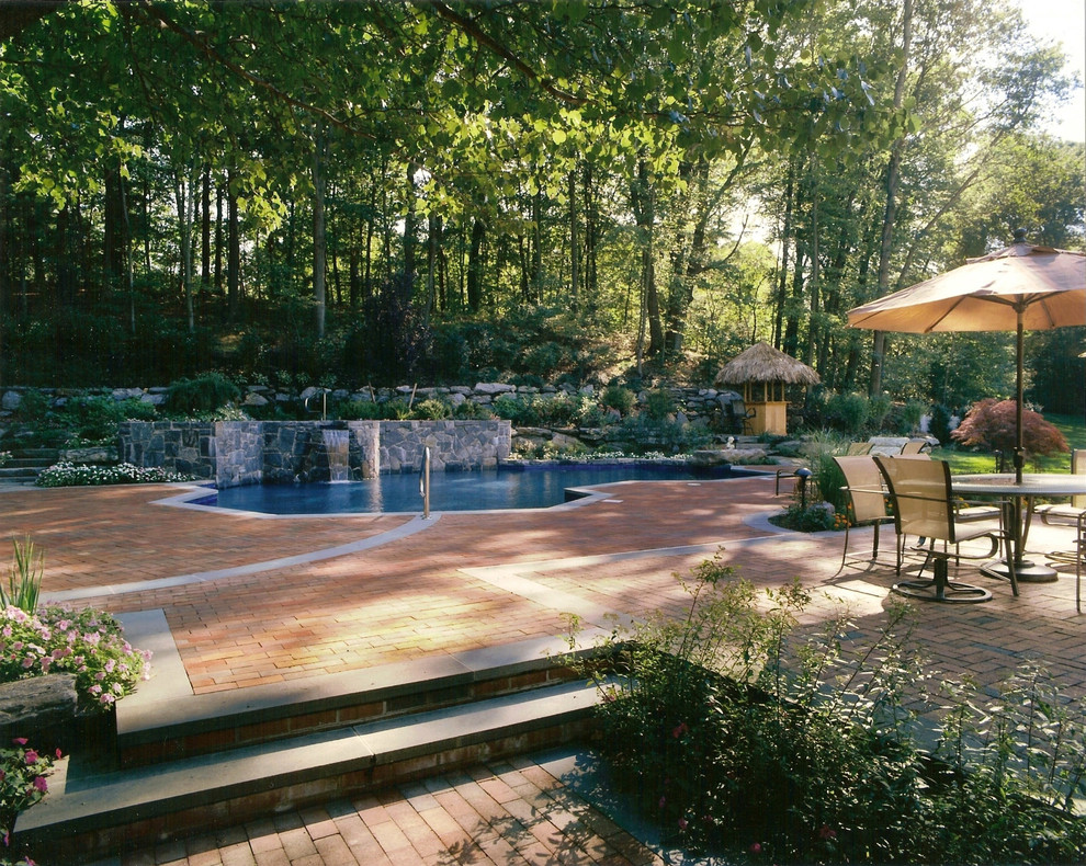 Large contemporary backyard patio in New York with a water feature and brick pavers.