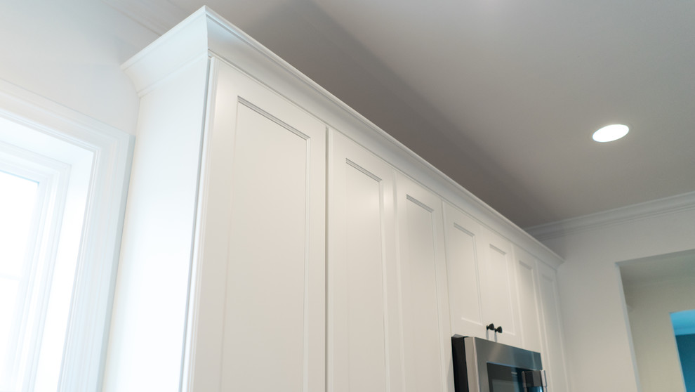 Open concept kitchen - mid-sized transitional l-shaped dark wood floor open concept kitchen idea with an undermount sink, shaker cabinets, white cabinets, granite countertops, gray backsplash, stainless steel appliances and an island