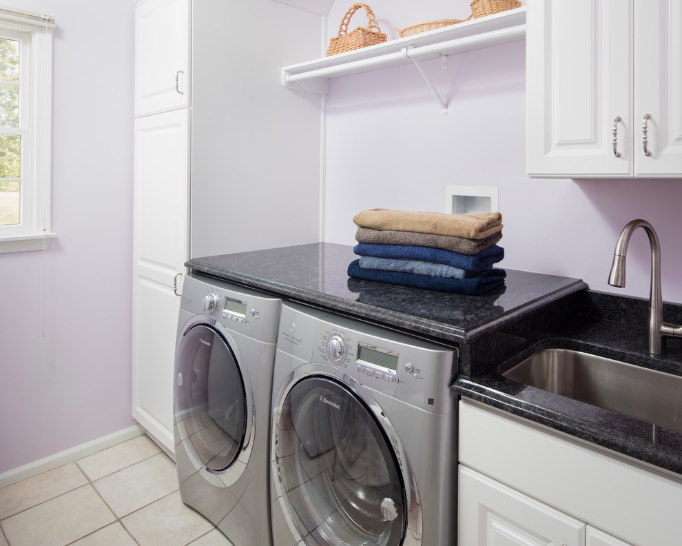 Inspiration for a large traditional laundry room in Philadelphia with raised-panel cabinets, black cabinets, white walls and porcelain floors.