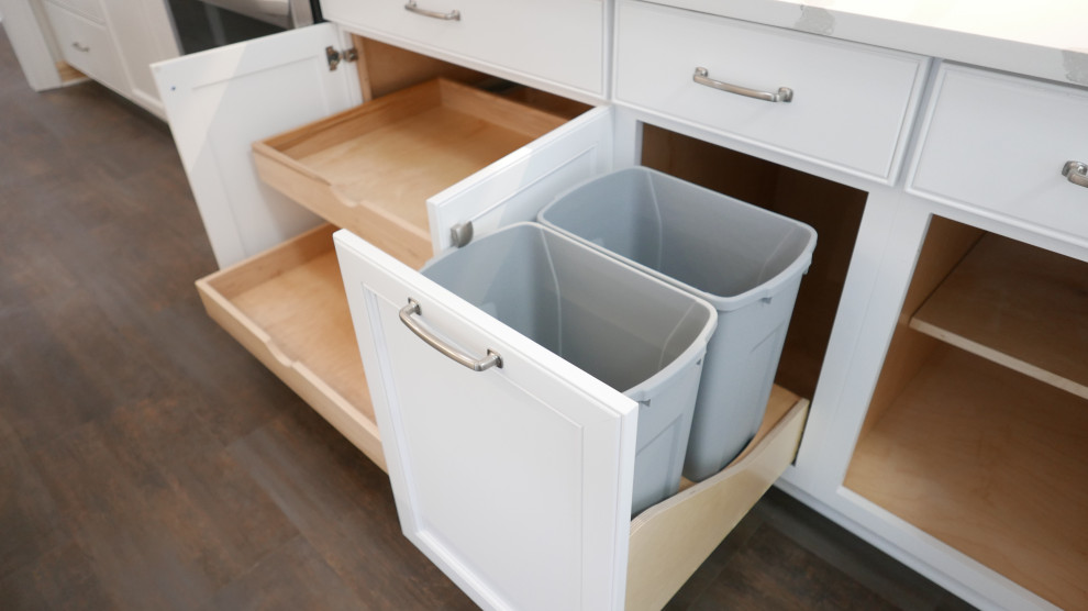 Mid-sized transitional galley laminate floor and multicolored floor eat-in kitchen photo with a farmhouse sink, shaker cabinets, white cabinets, quartz countertops, white backsplash, quartz backsplash, stainless steel appliances and white countertops