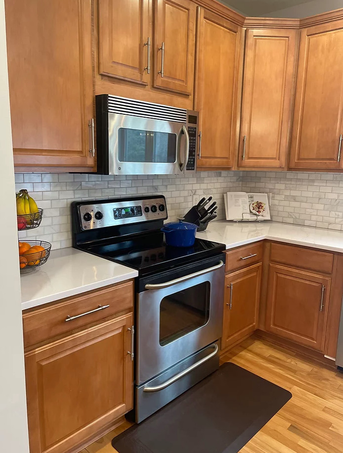 Inspiration for a mid-sized transitional u-shaped light wood floor and brown floor eat-in kitchen remodel in Minneapolis with a double-bowl sink, shaker cabinets, medium tone wood cabinets, quartz countertops, gray backsplash, marble backsplash, stainless steel appliances, an island and brown countertops